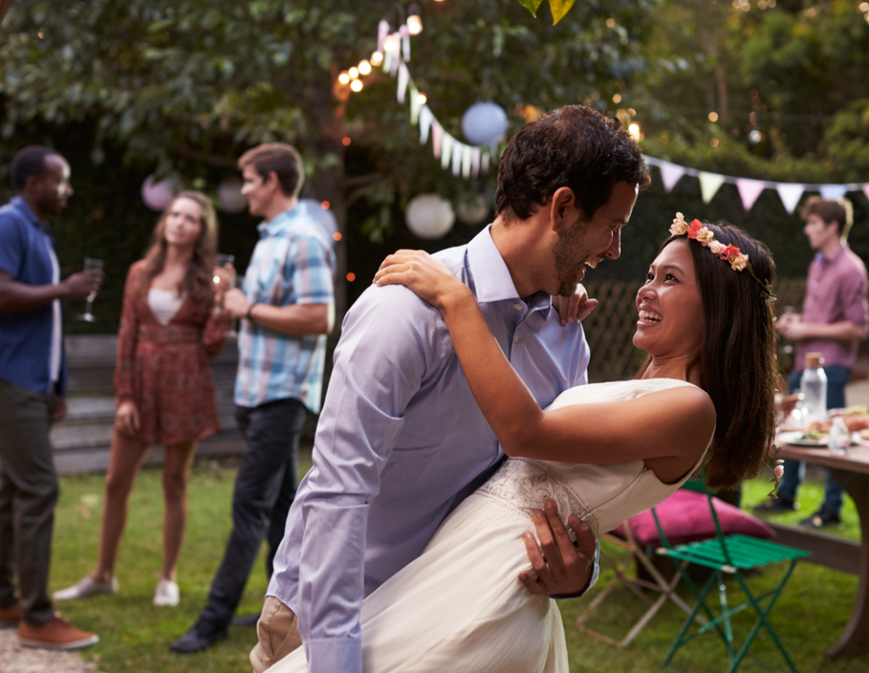 Young Couple Celebrating Wedding With Party In Backyard (Photo Credit: Monkey Business Images via Shutterstock)