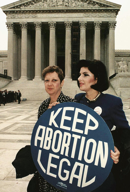 This file photo shows Norma McCorvey(L) formally known as "Jane Roe",as she holds a pro-choice sign with former attorney Gloria Allred(R) in front of the US Supreme Court building 26 April 1989,in Washington,DC, just before attorneys began arguing the 1973 landmark abortion decision which legalized abortion in the US.