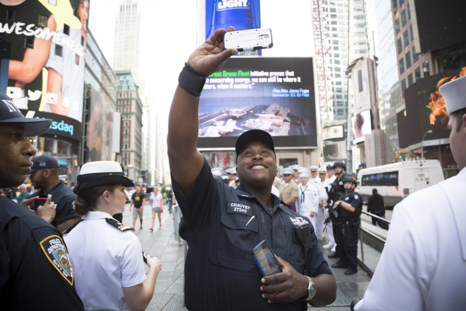 NEW YORK MAY 26 2016: Member of the NYPD takes a selfie with US Navy Sailors and Marines at the Armed Forces Recruiting Station on Military Island Pedestrian Plaza in Times Square for Fleet Week NY. (Photo Credit: Glynnis Jones) 