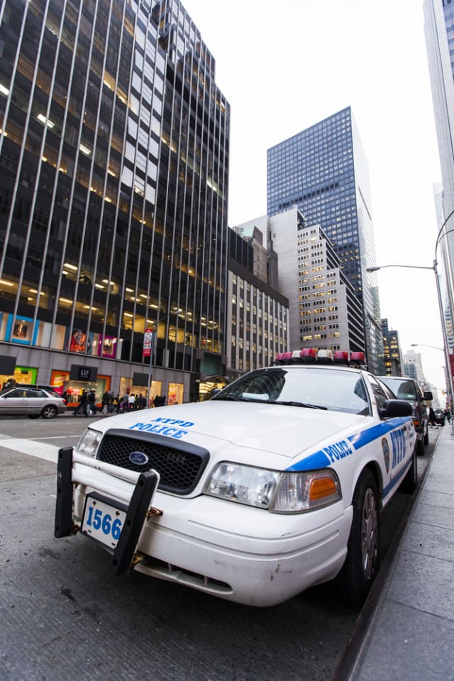 New-York, USA - NOV 20: Wide angle view of an NYPD police car parked by the pavement of a busy midtown Manhattan street, on the early evening of November 20, 2012 in New-York, USA. (Photo credit: elbud) 