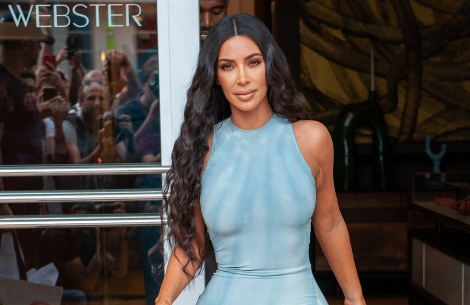 Kim Kardashian stands behind Kanye West and his drastic transformation