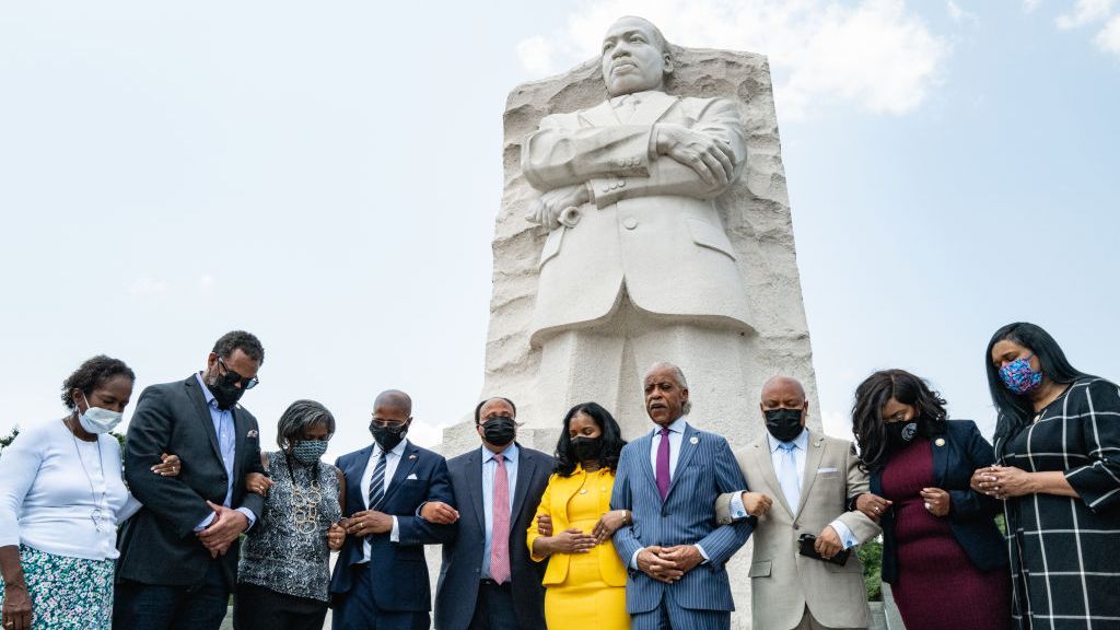 Martin Luther King III, his wife Arndrea Waters King, and Rev. Al Sharpton, stand with locked arms praying with Texas Legislative Black Caucus members, from left to right: Sheryl Cole, Jarvis Johnson, Rhetta Andrews Bowers, Ron Reynolds, Carl O. Sherman, Jasmine Crockett, and Shawn Thierry, at the Martin Luther King, Jr. Memorial in Washington, D.C. on July 28. (Cheriss May/Getty Images)