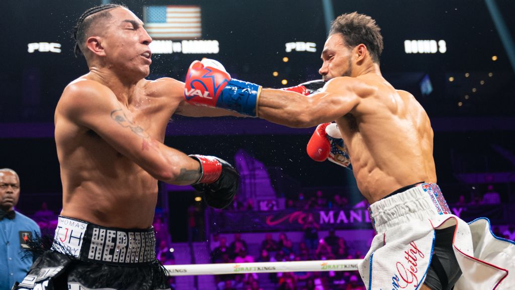 Keith Thurman (right) overcame a 31-month ring absence by dominating Saturday night's 147-pound clash of former champions, winning by unanimous decision over Mario Barrios (left) despite injury his left hand in the third round. (Ryan Hafey/Premier Boxing Champions)