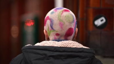 A woman with artistically coloured hair stands in Manchester city centre on November 24, 2021 in Manchester, England. (Photo by Christopher Furlong/Getty Images)