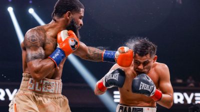 WBC/WBO 122-pound champion Stephen Fulton (left) lands a hard left hand on former titleholder Daniel Roman (right) during Saturday night's near shutout unanimous decision victory. (Esther Lin/Showtime)