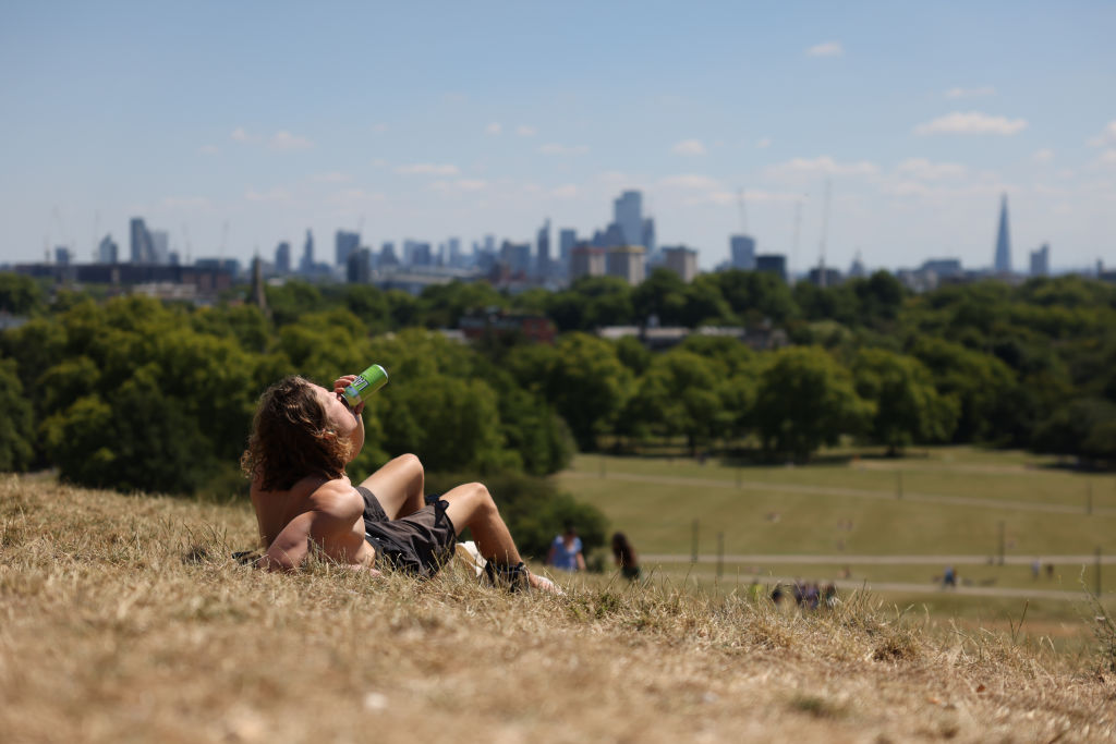 A man drinks a beer on Primrose Hill on July 10, 2022 in London, England. (Photo by Hollie Adams/Getty Images)