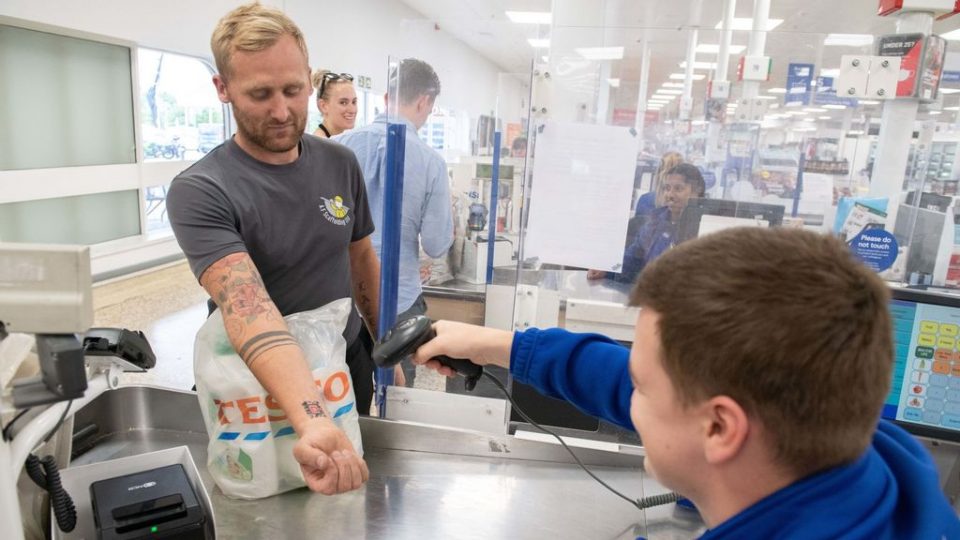 Dean Mayhew gets his tattooed Tesco clubcard QR code scanned at the cash register in Horsham, England . Mayhew previously kept forgetting to bring the card when going shopping, so he got the card tattooed in Chessington, in the U.K, on July 16, 2022. (SWNS/Zenger)