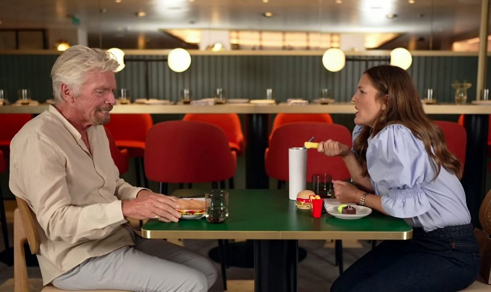 Drew Barrymore and Richard Branson tucking into a meal of plastic food - to highlight how humans consume nearly 50lbs of plastic in their lifetime. Undated photograph. (Bold Man Media, SWNS/Zenger)