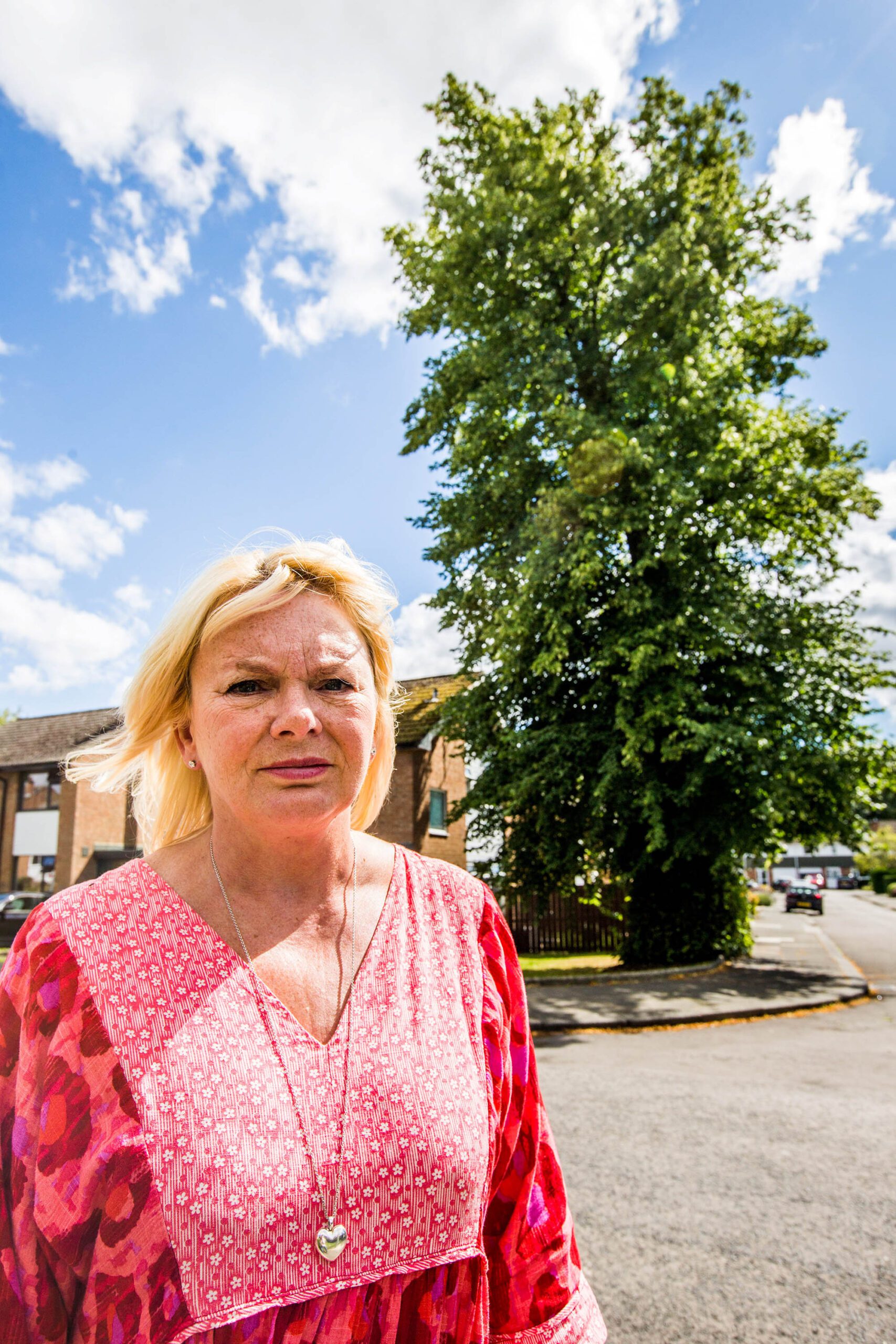 Celia Senior and the 72ft tree which towers over her home in Brompton Walk, in Darlington, in the United Kingdom. Undated photograph. (Stuart Boulton,SWNS/Zenger)