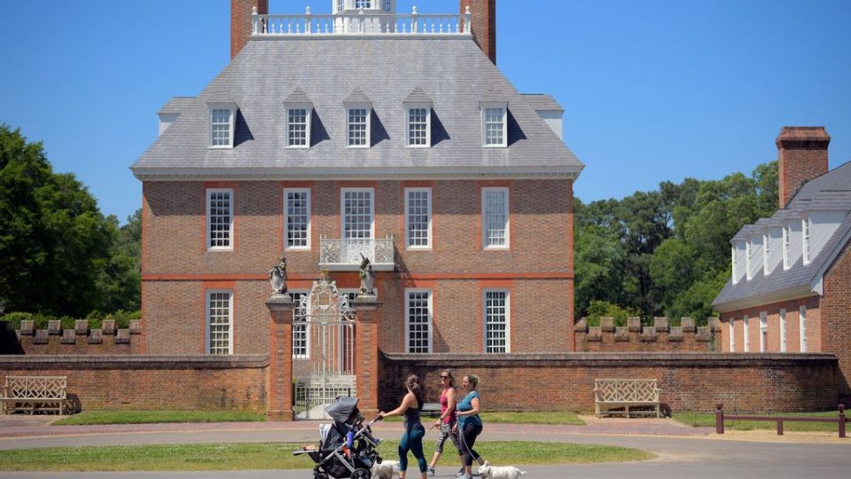 Kaley Campana, left, Anne Pinto, center, and Jennifer Hudgins stroll by the Governors Palace in a near empty Colonial Williamsburg that will open during phase 2 of the state's reopening plan in Williamsburg, VA on May 15, 2020. (Photo by John McDonnell/The Washington Post via Getty Images)