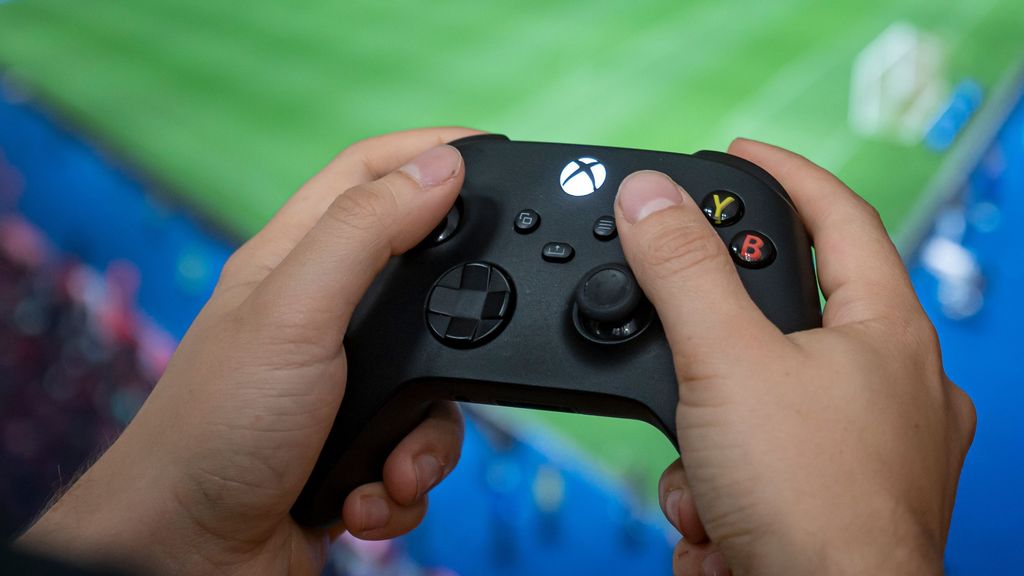A man holds a controller of the Xbox Series X gaming console. Microsoft addressed the emulator ban allowing users to use older consoles. FABIAN SOMMER/BENZINGA
