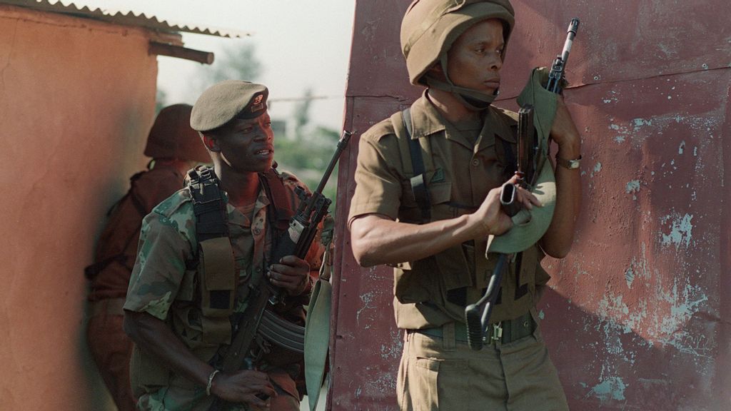 Members of the South African National Defense Force (SANDF) take up a position next to a shack in the black Umlazi township outside Durban, South Africa, as supporters of the African National Congress and the Inkatha Freedom Party clashed outside a stadium where President Nelson Mandela addressed a May Day rally, 01 May 1995. A new book looks at the legacy of Black African soldiers who fought in South African forces from the 1970s into the early 1990s. WALTER DHLADHLA/AFP via Getty Images)