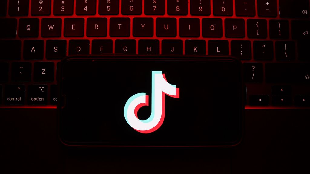 A laptop keyboard and TikTok logo displayed on a phone screen are seen in this illustration photo taken in Krakow, Poland on May 7, 2023. JAKUB PORSZYCKI/SWNS TALKER