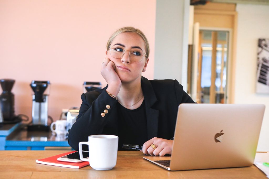 Lady deep in thought next to a laptop. For many, age 31 marks a decade of work, suggesting that workers get a ‘10-year career itch’ to switch jobs. MAGNET.ME VIA UNSPLASH