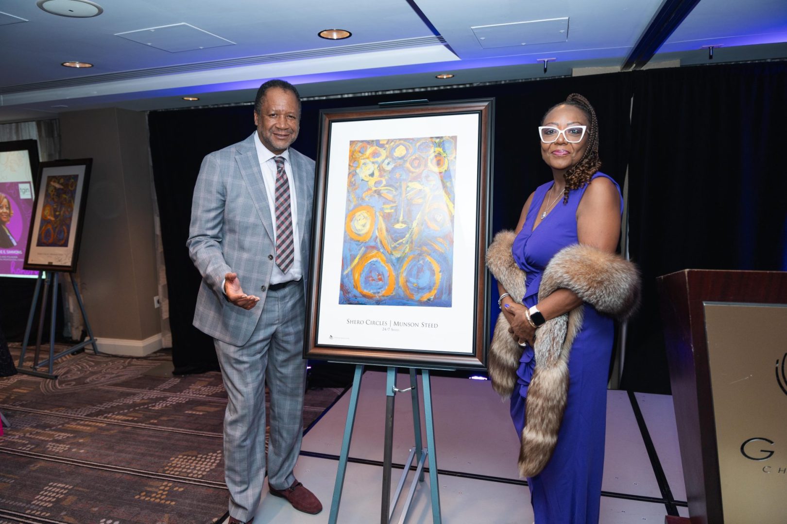 Rolling Out Publisher and CEO Munson Steed presenting Sisters with Superpowers Chicago Honoree Terrie Simmons with her award and token of appreciation: commissioned artwork by Steed titled 'Shero Circles'